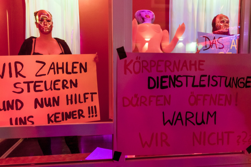 Hamburg: Eine Prostituierte hält in der Herbertstraße ein Schild mit der Aufschrift "Wir zahlen Steuern und nun hilt uns keiner!". Sie demonstriert mit anderen Frauen für die Öffnung der Bordelle auf St. Pauli.