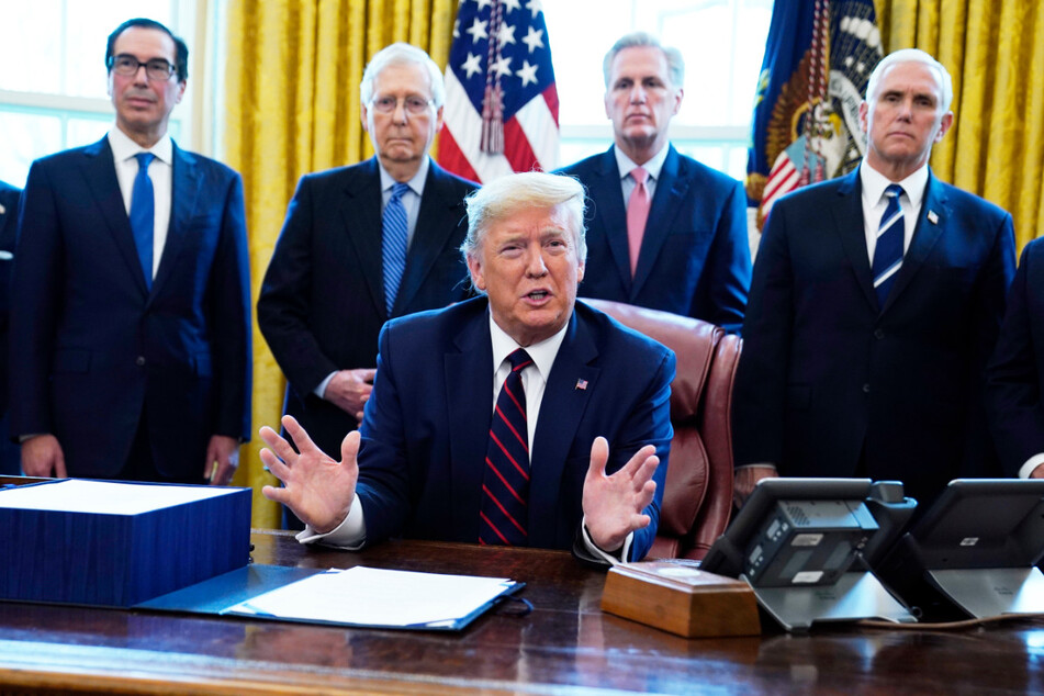 Donald Trump (Mi.) unterzeichnete am Freitag das Coronavirus-Konjunkturpakets im Oval Office des Weißen Hauses - umringt von zahlreichen Mitarbeitern ohne den erforderlichen Mindestabstand.