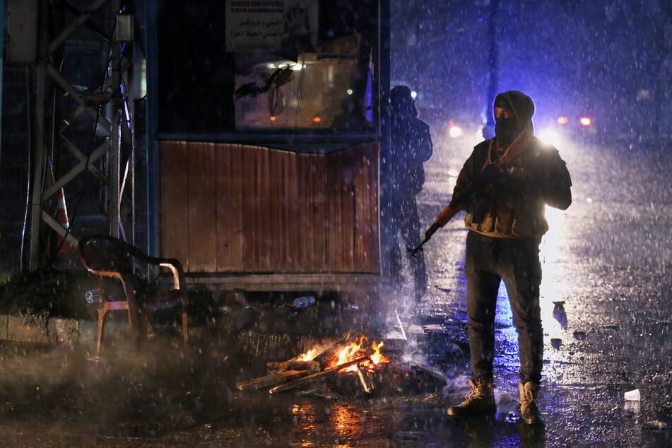 Bewaffnete kurdische Freiwillige stehen während einer nächtlichen Patrouille an einem Kontrollpunkt Wache. (Archivbild)