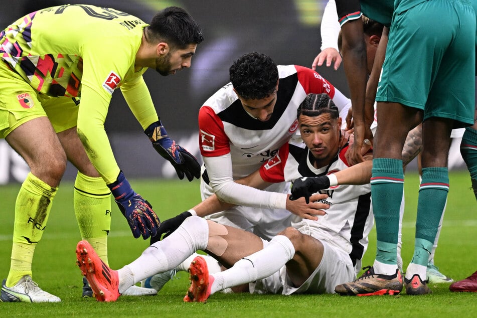 Mit- und Gegenspieler waren in der 12. Minute in Sorge um Eintracht Frankfurts Mittelstürmer Hugo Ekitiké (r.), der aus luftiger Höhe mit dem Kopf auf den Boden prallte.