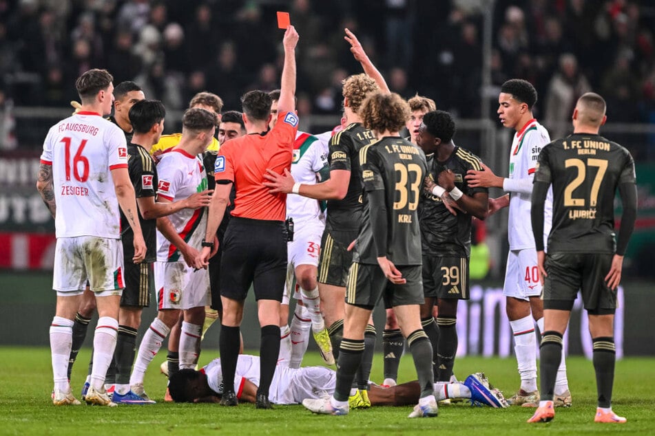 Schiedsrichter Florian Badstübner (4.v.l.) zeigt Derrick Köhn (3.v.r.) die Rote Karte.