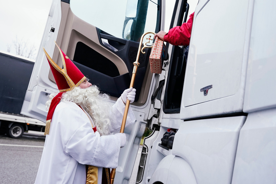 Der Nikolaus reicht einem Lkw-Fahrer auf der Raststätte Wonnegau bei Worms sein Präsent.