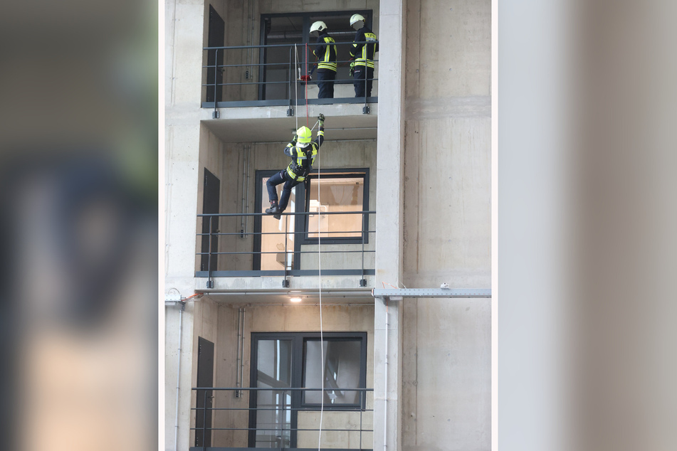 Ein Feuerwehrmann seilt sich bei der Eröffnung der Ausbildungs- und Fahrzeughalle der Thüringer Landesfeuerwehrschule von einem Balkon ab.