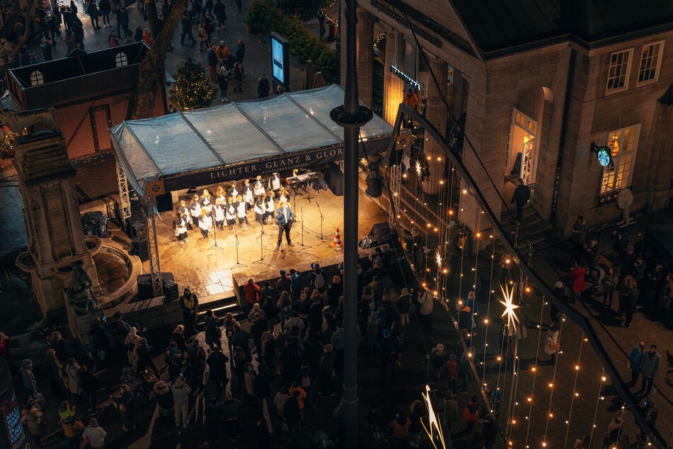 Auf der Bühne neben dem Mönckebergbrunnen laden zahlreiche Musiker zum vorweihnachtlichen Mitsingen ein.