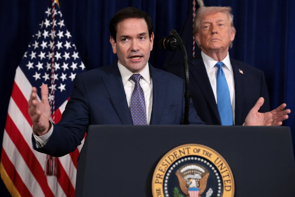 Secretary of State Marco Rubio speaks as President Donald Trump stands behind him during a press conference following a US attack on Venezuela from the Mar-a-Lago club in Palm Beach, Florida, on January 3, 2026.