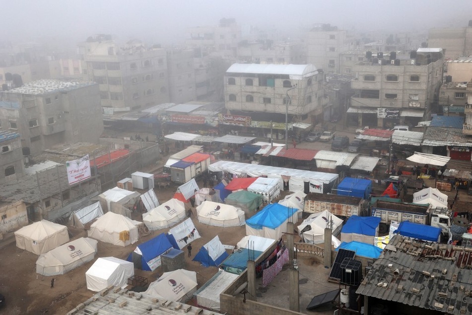 Fog covers buildings and tents set up by displaced Palestinians in Rafah in the southern Gaza Strip on February 25, 2024.