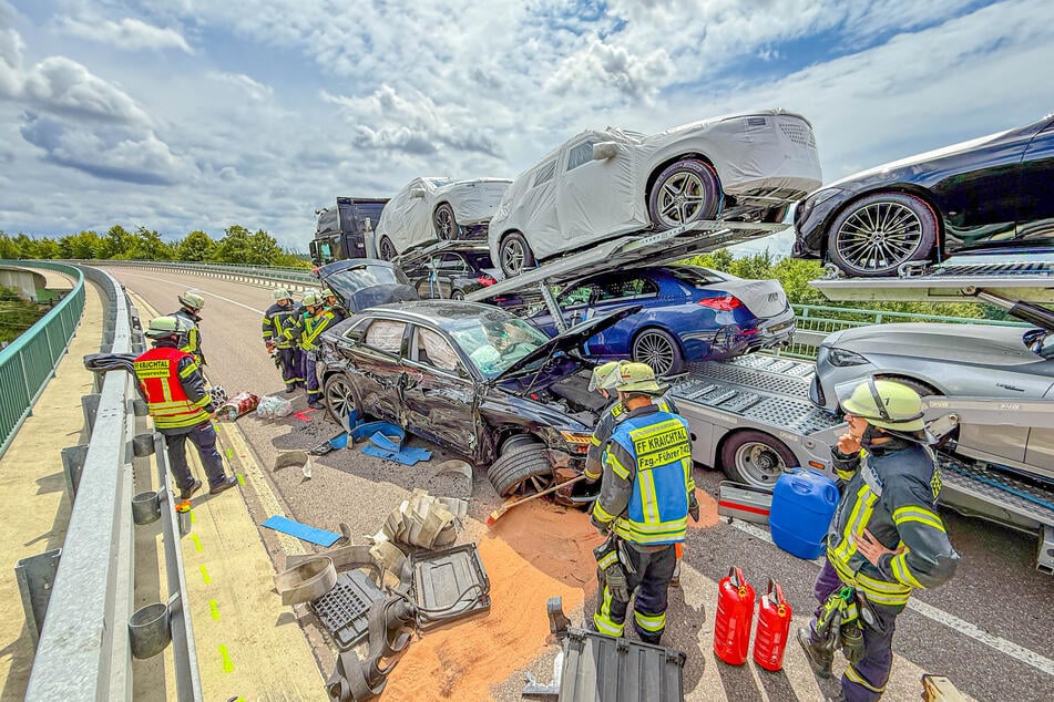 Einsatzkräfte der Feuerwehr beseitigen das Trümmerfeld, nehmen die ausgelaufenen Betriebsstoffe mittels Bindemittel auf.