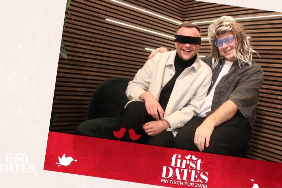 In der Fotobox legt Philipp (22) den Arm um sein Date Lukas (24), während beide in die Kamera strahlen.