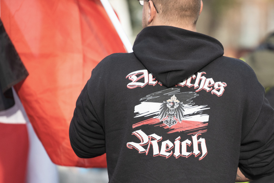 Ein Mann trägt einen Pullover mit dem Aufdruck "Deutsches Reich" bei einer Demonstration von Reichsbürgern in Potsdam.