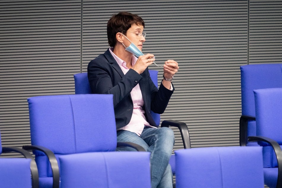 Frauke Petry, parteilos, schaut ihre Mund-Nasenbedeckung während der Sitzung des Bundestags an.