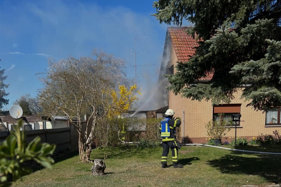 Das Feuer beschädigt die Fassade eines angrenzenden Hauses.