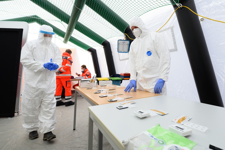 Mitarbeiter der Johanniter-Unfall-Hilfe Dresden bereiten sich auf Antigenschnelltest auf das Coronavirus in einem Zelt auf dem Messegelände vor.
