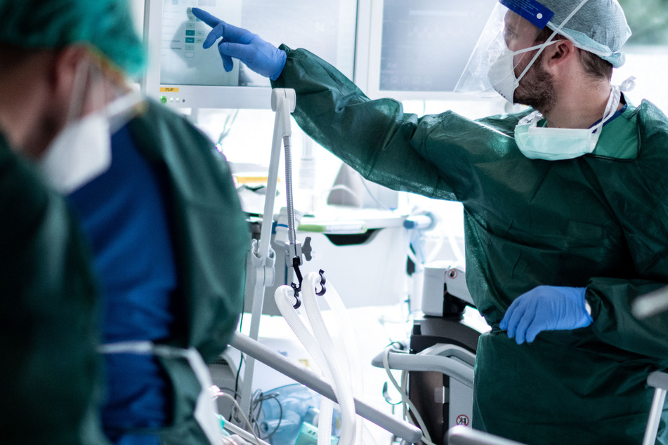 Nordrhein-Westfalen, Essen: Mitarbeiter der Pflege in Schutzkleidung behandeln einen Patienten mit Corona-Infektion auf der Intensivstation IT2 im Operativen Zentrum II des Universitätsklinikums Essen.