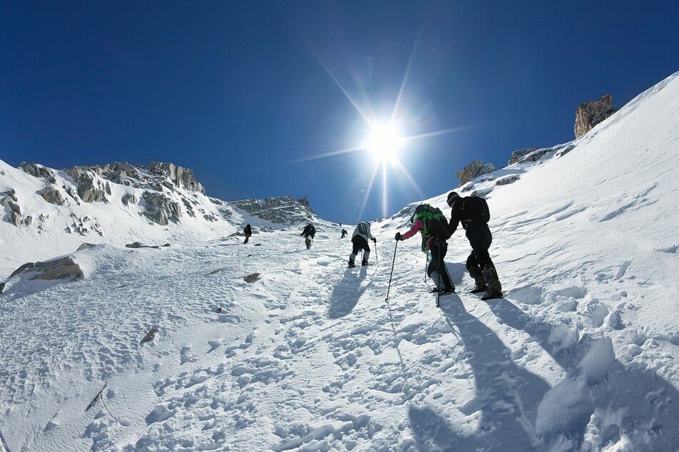 Adventurers climbing through ice and snow (stock image).