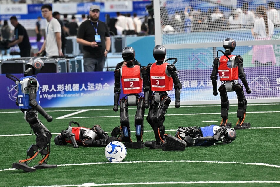 Robots compete in a 5x5 soccer match during the World Humanoid Robot Games in Beijing, China, on August 15, 2025.