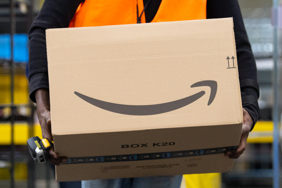 Ein Sortiermitarbeiter von Amazon trägt ein Paket. In Schwaben wurden die Beschäftigten dazu aufgerufen, ihre Arbeit niederzulegen. (Symbolbild)
