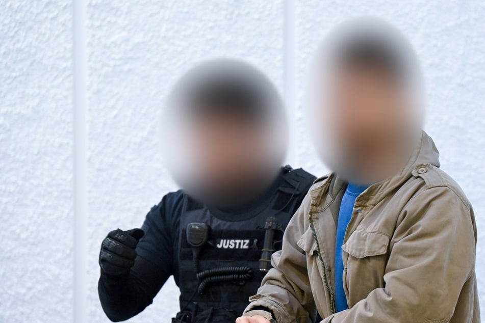 Ein Angeklagter (r.) wird zu Beginn seines Prozesses in den Gerichtssaal geführt.