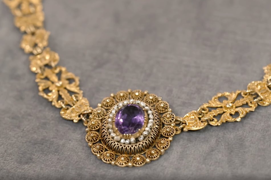 Das opulente Collier aus 750er-Gold sticht vor allem durch den sechs Karat schweren Amethyst als zentralem Schmuckstein ins Auge.