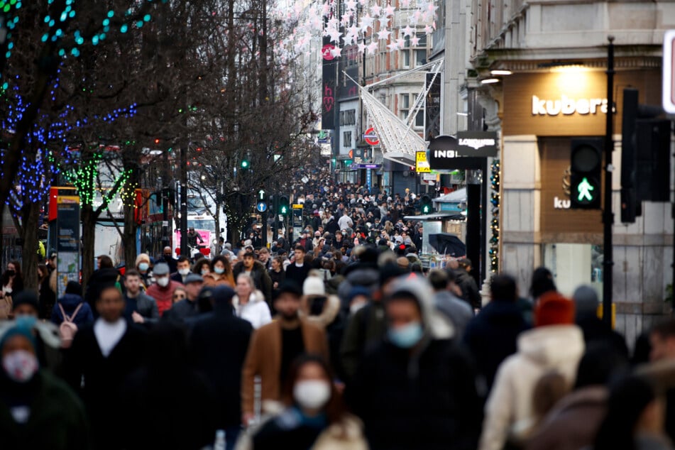 Unzählige Einkäufer, einige mit Mund-Nasen-Schutz, bevölkern die Oxford Street in London.