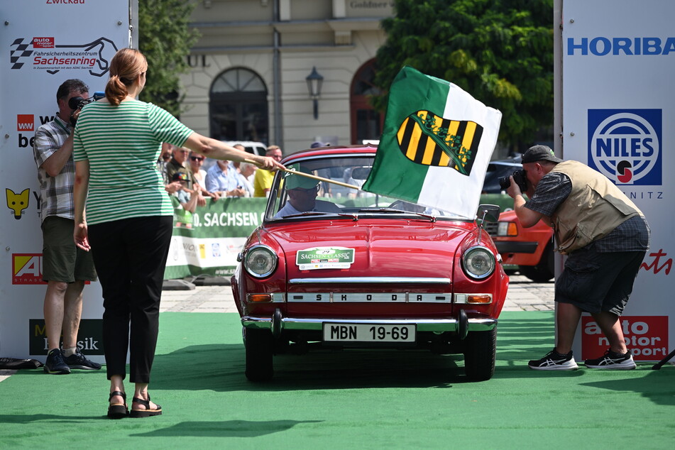 Bürgermeisterin Constance Arndt schwenkt die Startflagge zum Rallye-Auftakt.