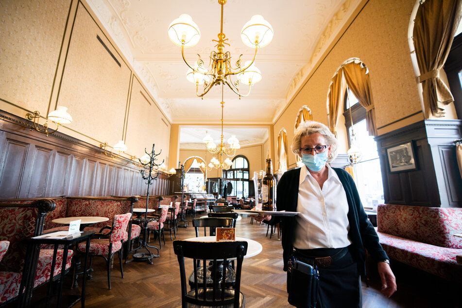 Eine Kellnerin mit Mund- und Nasenschutz wartet im Cafe Sperl in Wien auf Gäste.