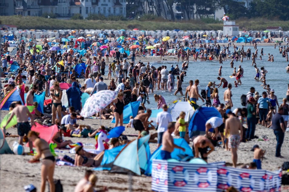 Menschen nutzen am Samstag das sommerliche Wetter in Warnemünde.