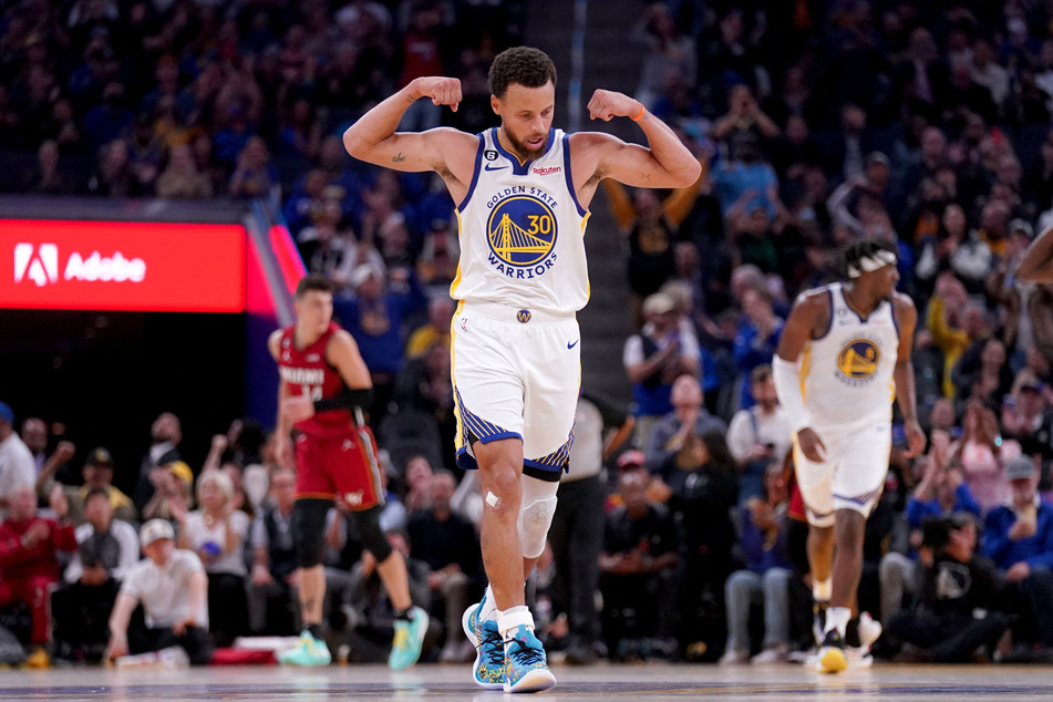 Golden State Warriors guard Stephen Curry flexes after the Warriors score a basket against the Miami Heat in the fourth quarter at the Chase Center.