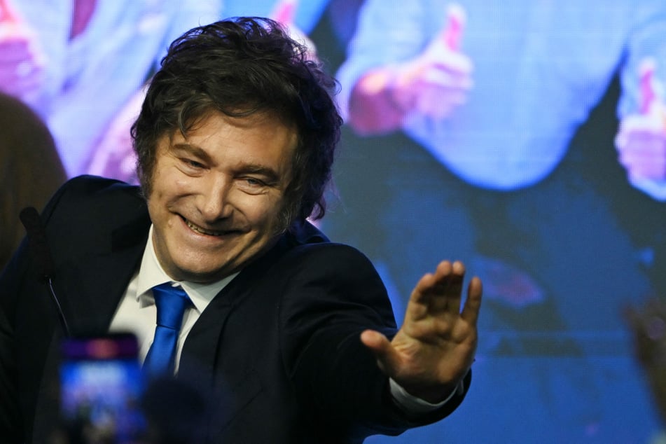 Argentina's President Javier Milei waves to supporters as he arrives at the ruling party's La Libertad Avanza headquarters following the results of the national midterm legislative election in Buenos Aires on October 26, 2025.