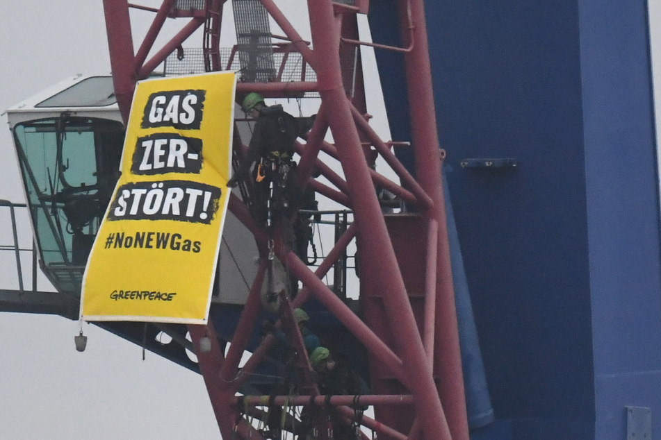 Auf dem Verladekran im Hafen von Mukran hat ein Aktivist von "Greenpeace" ein Banner angebracht.