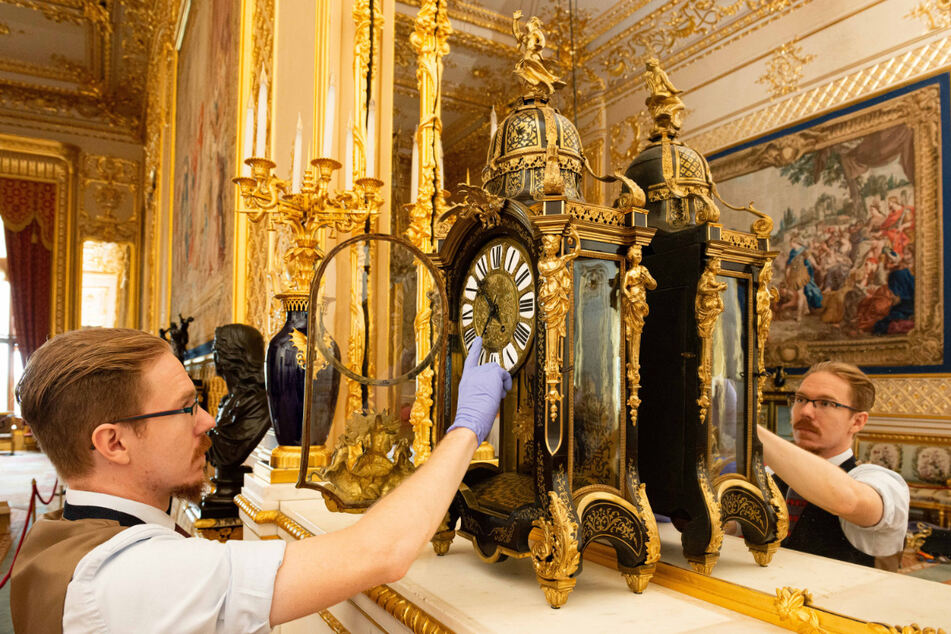 Ein Uhrmacher und Restaurator stellt im Großen Empfangssaal von Schloss Windsor eine Uhr aus dem späten 19. Jahrhundert auf die Winterzeit um.