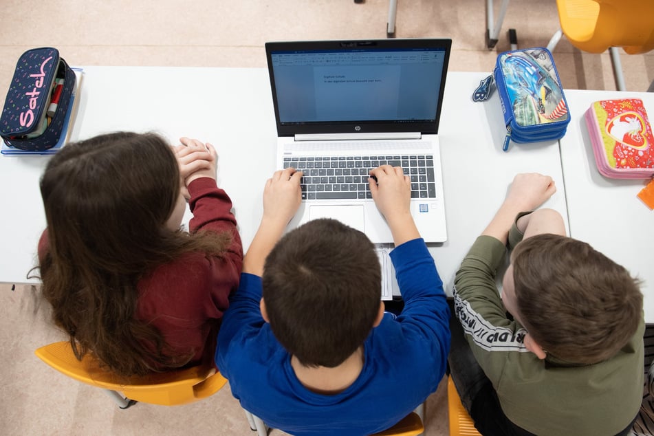Drittklässler vor einem Laptop in einer Freiberger Grundschule.