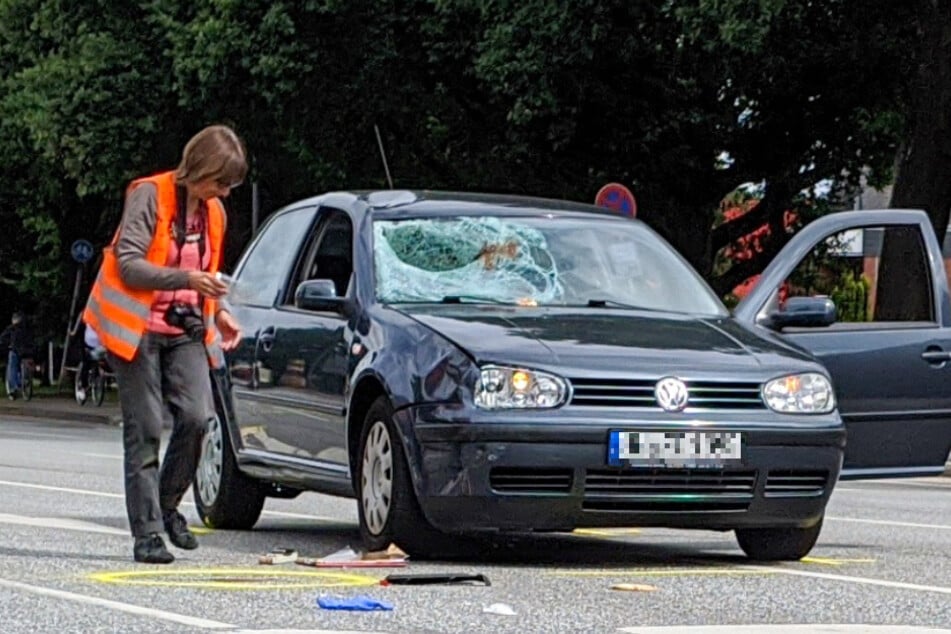 Eine Mitarbeiterin des Verkehrsunfalldienstes untersucht das Auto nach dem Unfall.