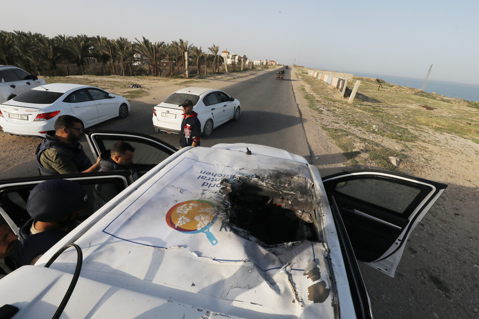 Palästinensische Gebiete, Dair El-Balah: Palästinenser inspizieren die schwer beschädigten Fahrzeuge der in den USA ansässigen internationalen ehrenamtlichen Hilfsorganisation World Central Kitchen (WCK).