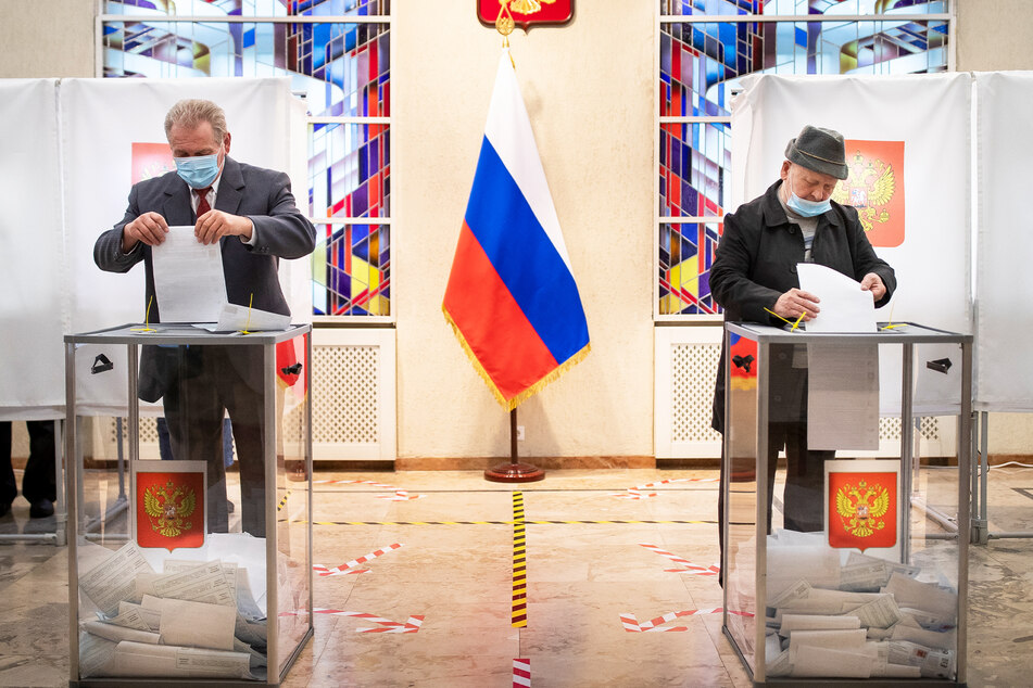 Zwei Russen werfen ihre Stimmzettel in die Wahlurnen in der russsischen Botschaft in Litauen.