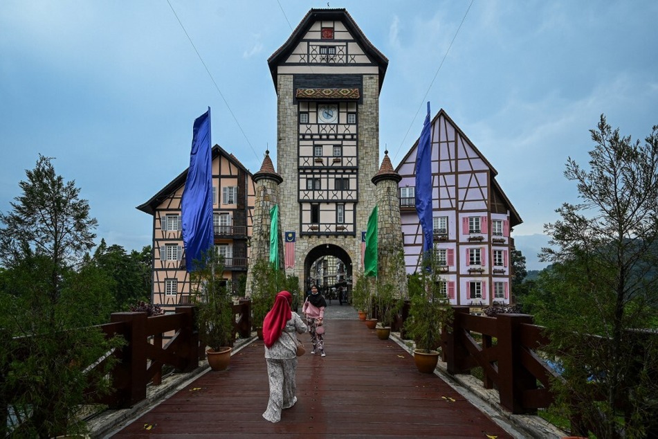 Visitors take pictures at a French-themed village in Malaysia called Colmar Tropicale.