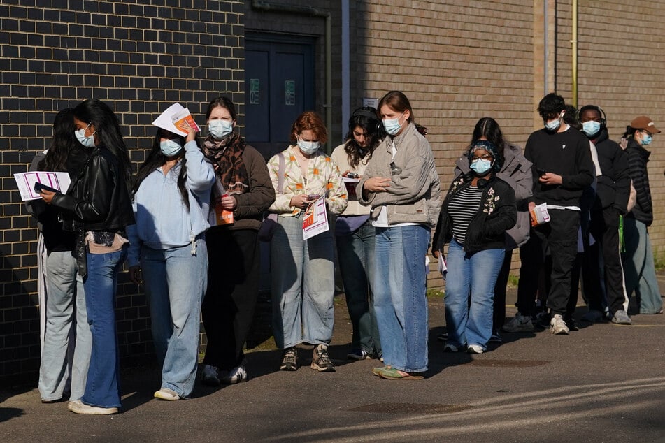 Studenten stehen auf dem Campus der Universität von Kent in Canterbury Schlange, um Impfstoffe und Antibiotika zu erhalten.