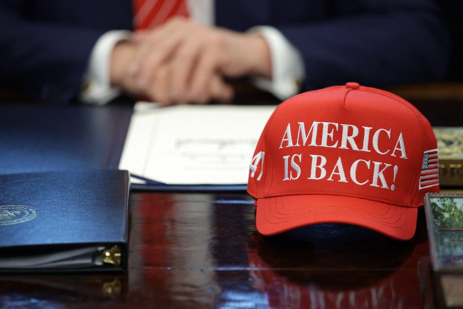 A hat reading "America is Back!" sits in front of President Donald Trump during a bill signing in the Oval Office of the White House on February 03, 2026.