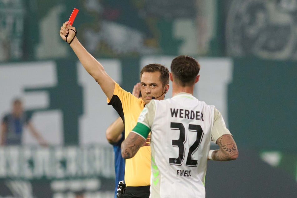 Leonardo Bittencourt (nicht im Bild) sieht die Rote Karte, während Werder-Kapitän Marco Friedl mit dem Schiedsrichter diskutieren will.