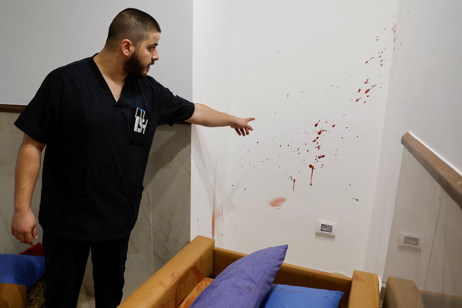 A doctor at Ibn Sina Hospital shows the bloody scene left behind by Israeli forces.