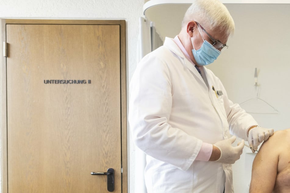 Ein Hausarzt aus der Schweiz impft in seiner Praxis einen Patienten. Auch in Mecklenburg-Vorpommern das nun möglich sein.
