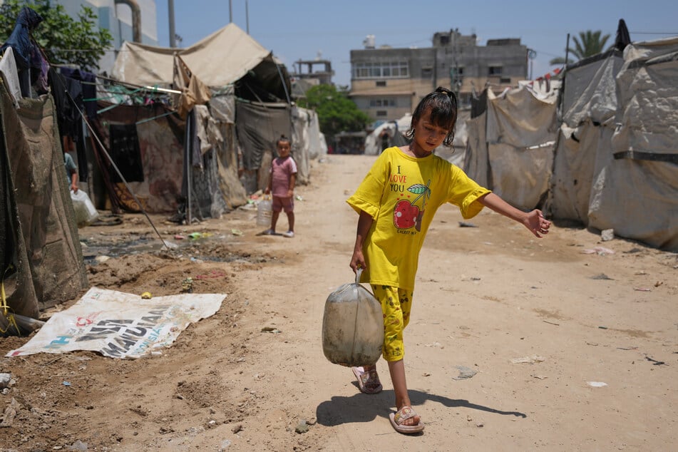 Sie können nichts dafür und müssen so sehr leiden: Vertriebene palästinensische Kinder tragen in Deir al-Balah im zentralen Gazastreifen gefüllte Wasserbehälter.
