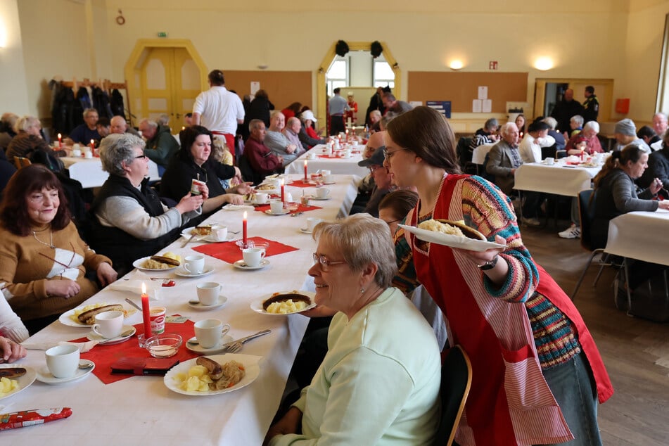 Die Helfer servieren den Menschen ihre warmen Mahlzeiten.