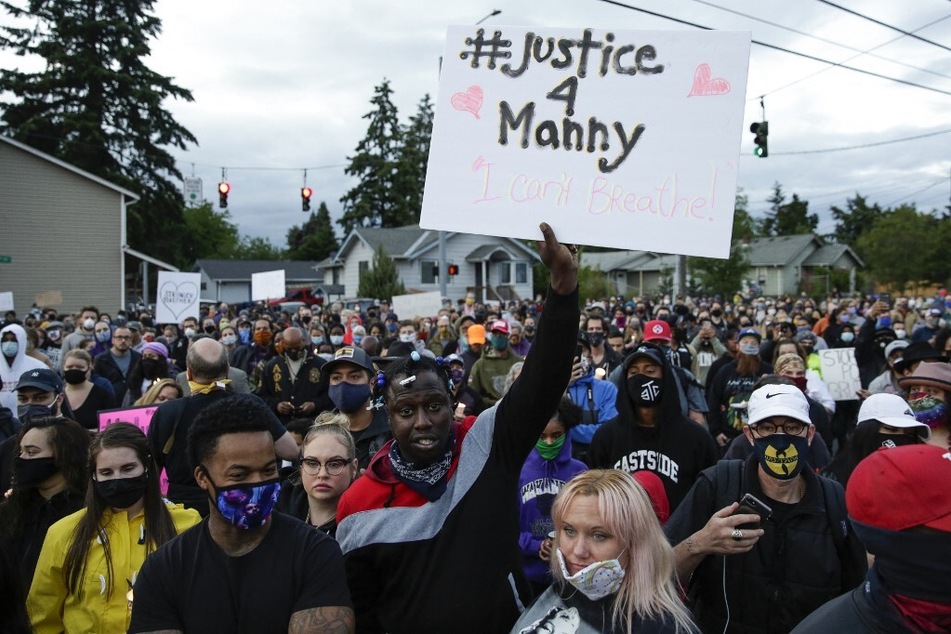 Family, friends, and community members attend a vigil at the intersection where Manuel Ellis, a 33-year-old Black man, died in Tacoma Police custody on March 3, 2020.