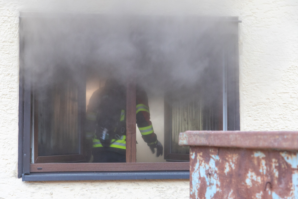 Rauch dringt aus dem Fenster des in Brand geratenen Wohnhauses.