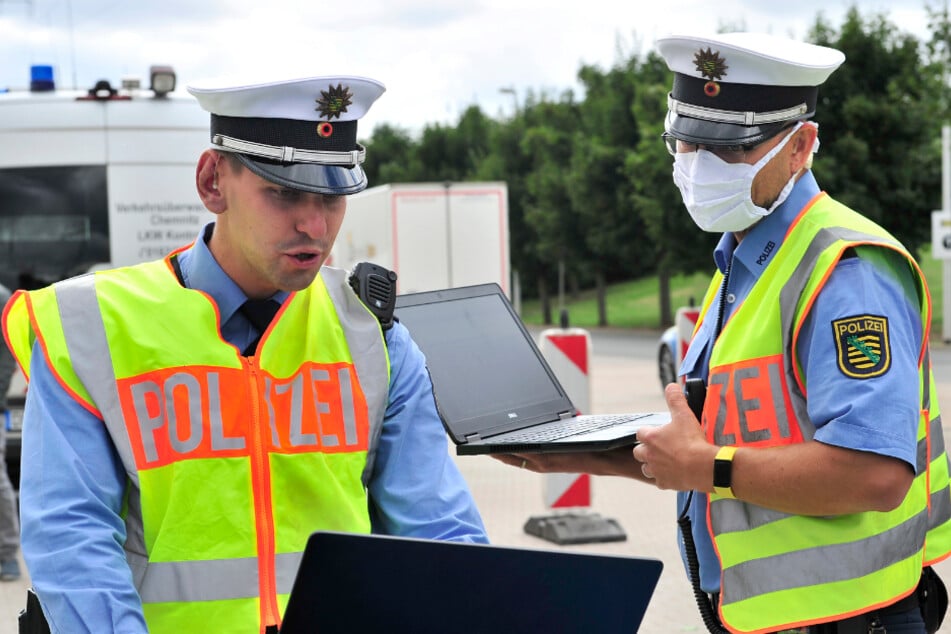 Elektronisches Lagezentrum auf der Motorhaube: Polizeioberkommissar Gunar Schreiber (31, l.) beobachtet die Live-Bilder aus dem Hubschrauber.
