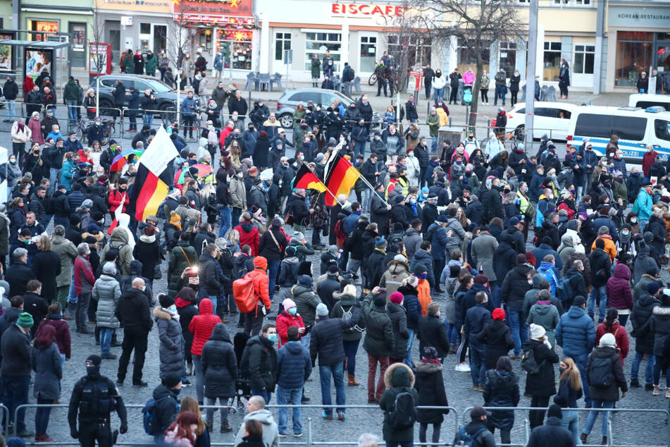 Teilnehmer einer Kundgebung "Thüringen steht zusammen" stehen auf dem Domplatz in Erfurt und protestieren gegen die Corona-Maßnahmen.
