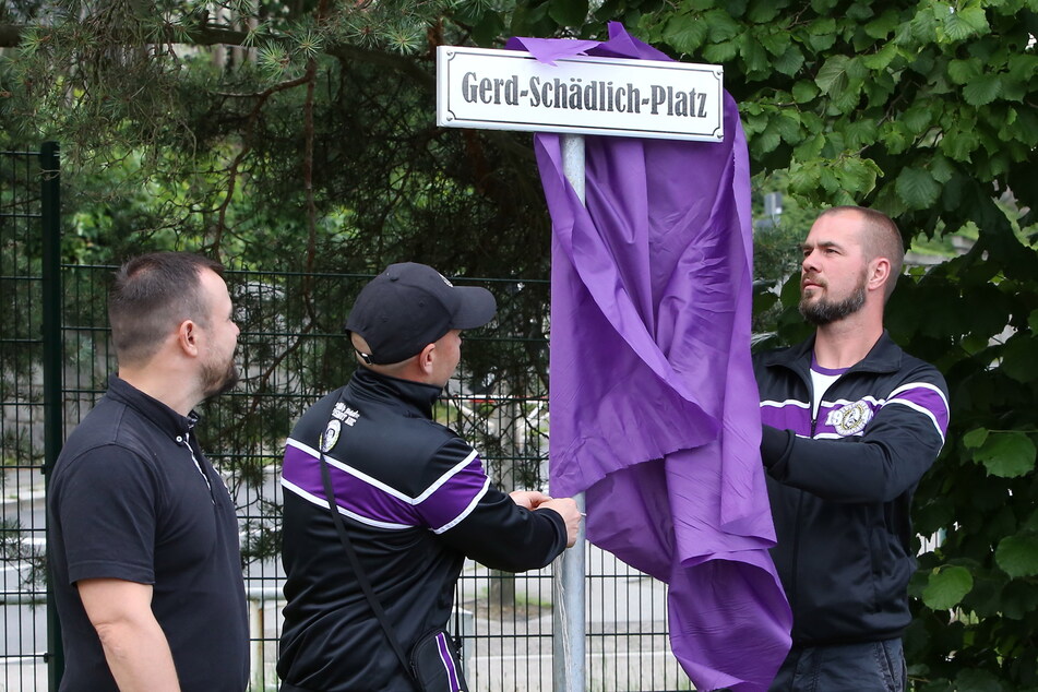 Jörg Püschmann, Stefan Schlenkrich und André Zeuner (v.l.) enthüllen das Schild zum "Gerd-Schädlich-Platz".