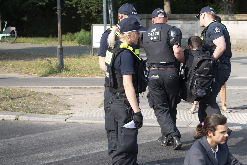 Einsatzkräfte der Berliner Polizei trugen die Aktivisten von der Straße, damit der Verkehr um die Siegessäule wieder fließen konnte.