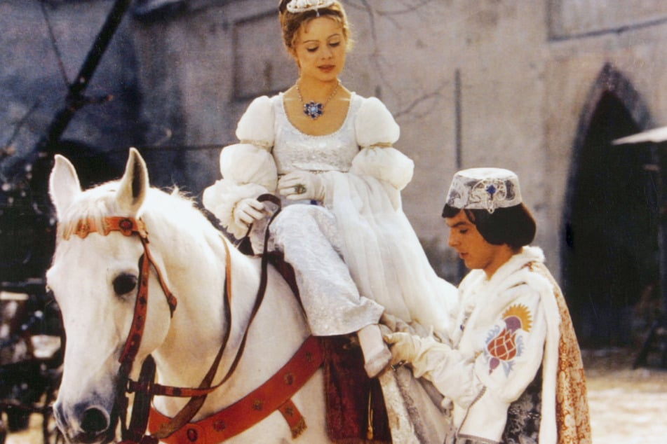 Der Prinz (Pavel Trávnícek) passt Aschenbrödel (Libuse Safránková) den verlorenen Schuh an in einer Szene aus "Drei Haselnüsse für Aschenbrödel".