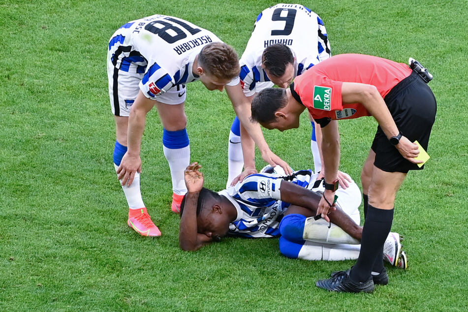 Herthas Santiago Ascacbiar (l.) und Vladimir Darida (M) kümmern sich um den verletzten Jhon Cordoba (am Boden). Der Kolumbianer fällt für den Rest der Saison aus.
